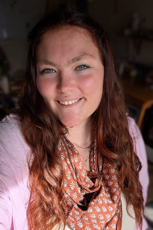 Portrait de Lilie, souriante, cheveux longs et écharpe rousse